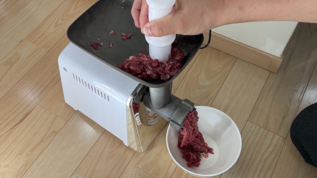 自分で解体したキョンの前足肉をミンチ肉にしてます。